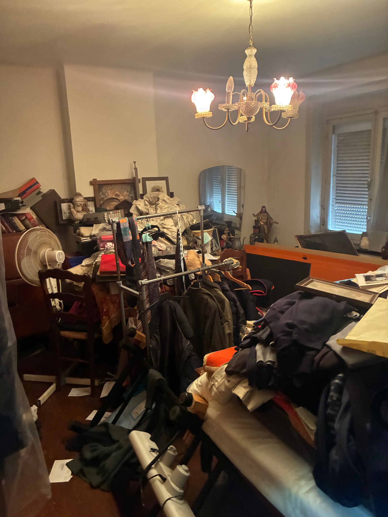 Woonkamer met opgehoopte meubelen, kleding, kunst en andere goederen