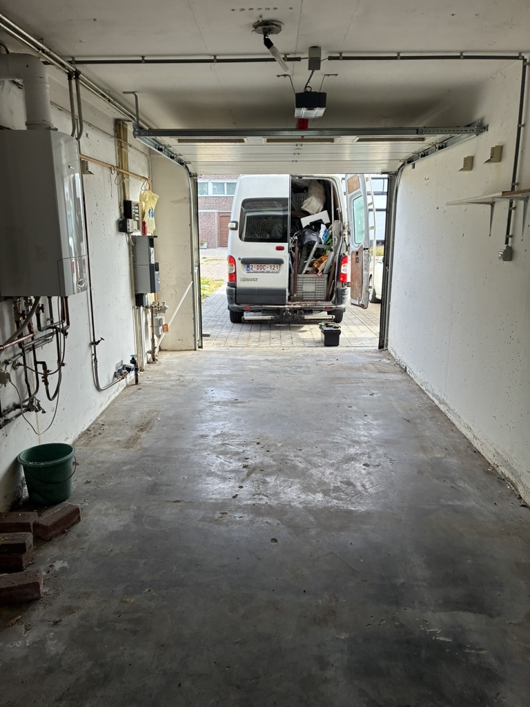 Vrijgemaakte garage met een geladen bestelwagen aan de open poort